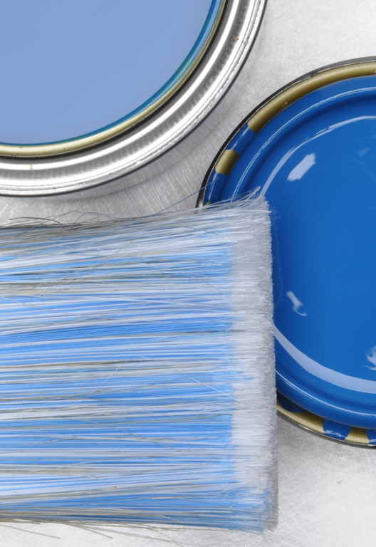 Draufsicht auf blaue Farbdose mit Pinsel auf grauem Metallhintergrund